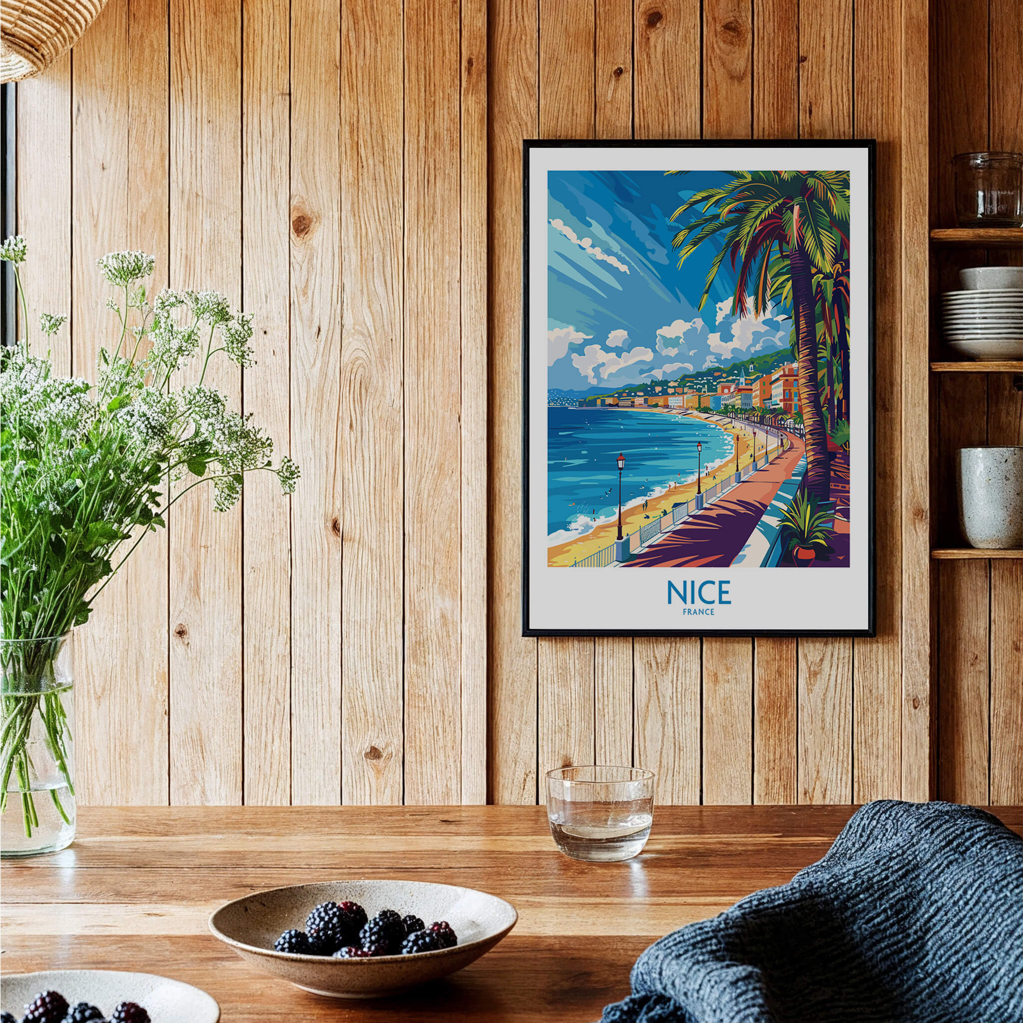 Nice Wall Art Poster - France displayed in a cozy room with wooden decor and vibrant coastal scenery.