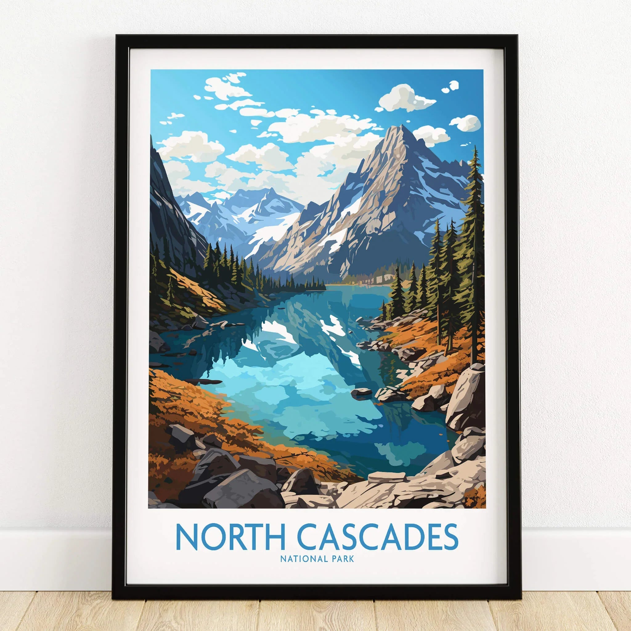 North Cascades National Park art print with lake, mountains, and pine trees in black frame on floor