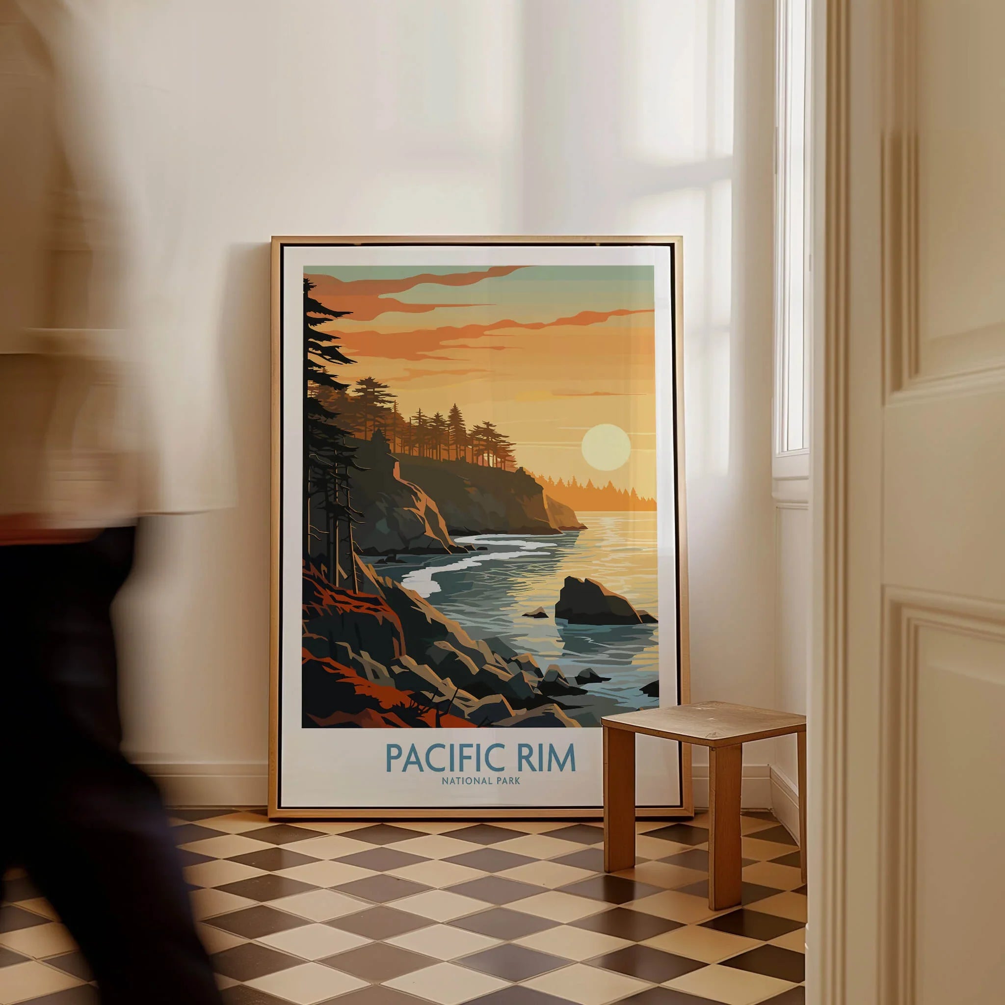 Framed Pacific Rim National Park travel poster with coastal sunset, leaning on floor in modern room.