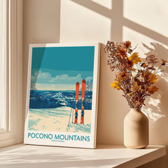Pocono Mountains ski travel poster with snowy landscape and skis, next to a vase of flowers