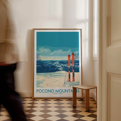 Pocono Mountains ski poster print with snowy landscape and skis, leaning on wall in hallway