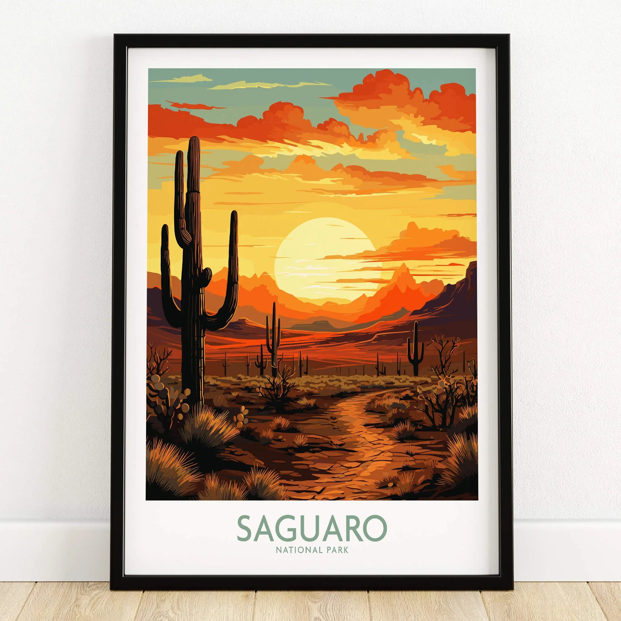 Saguaro National Park art print in black frame on wooden floor, featuring sunset desert landscape with cacti.