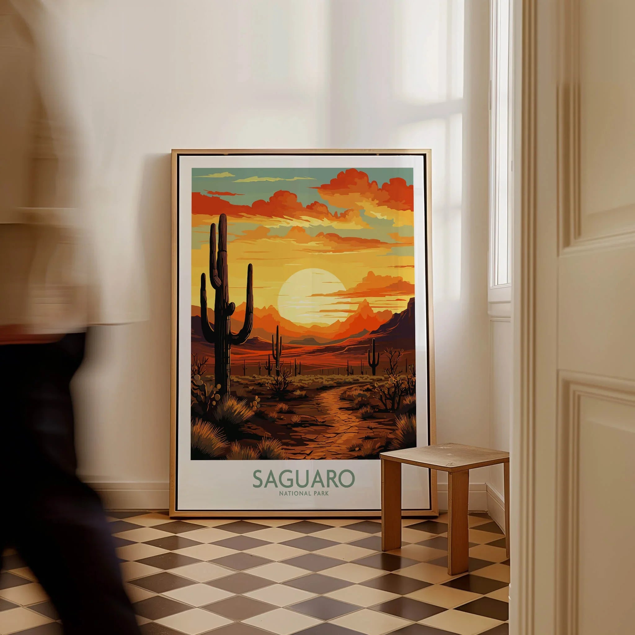 Framed Saguaro National Park poster with desert sunset and cacti on floor, man walking by