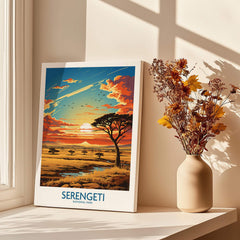 Serengeti National Park poster with sunset landscape, acacia trees, and vase of dried flowers on windowsill