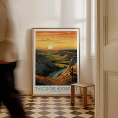 Framed Theodore Roosevelt National Park poster with sunset landscape on floor, man walking past.