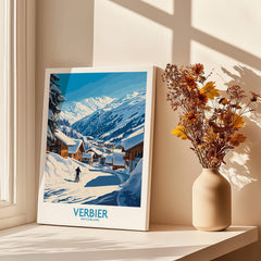 Verbier Ski Poster Switzerland displayed beside vase of flowers, showcasing snowy mountains and charming village scenery.