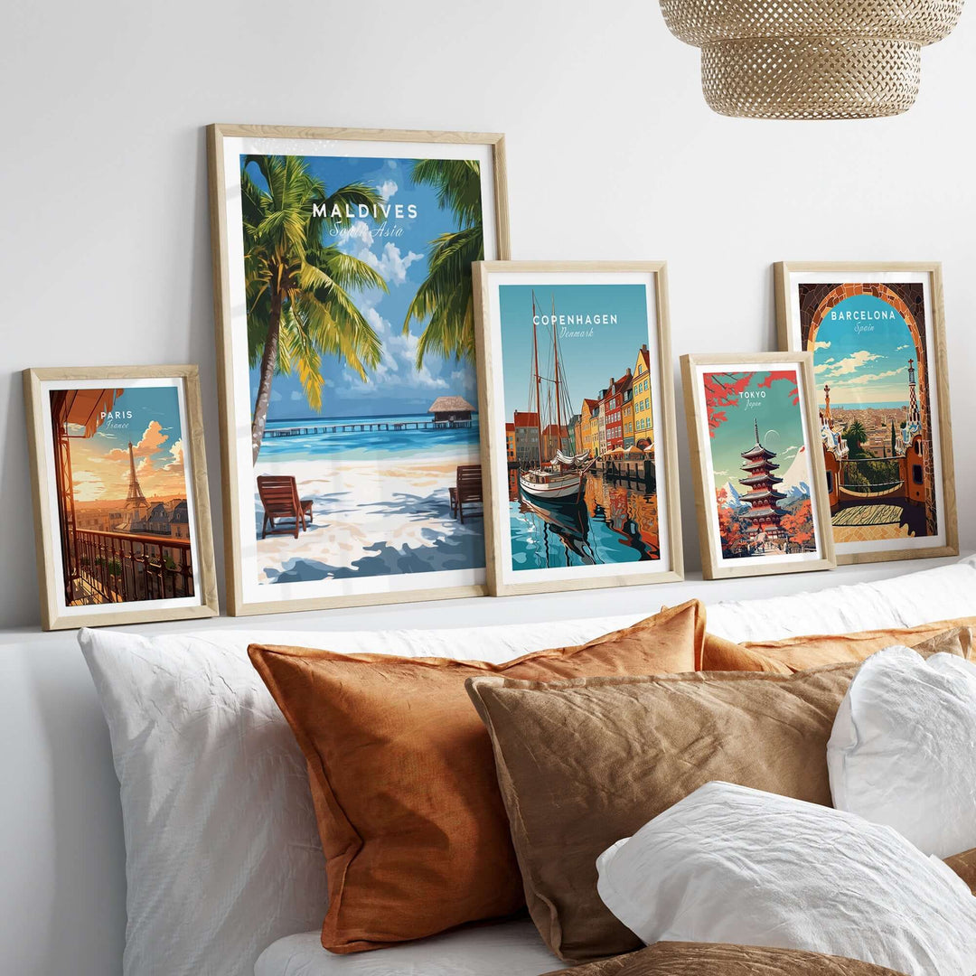 Maldives poster featuring a tropical beach scene, displayed among other vibrant city posters on a cozy bed setting.