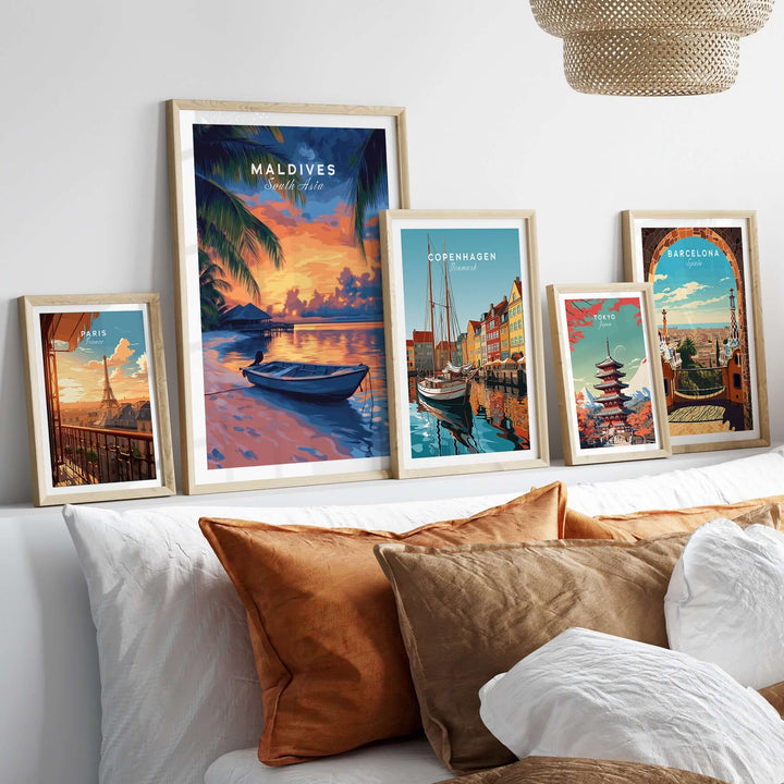 Framed travel prints featuring Maldives sunset, Copenhagen, and Barcelona, displayed on a cozy bedroom wall.