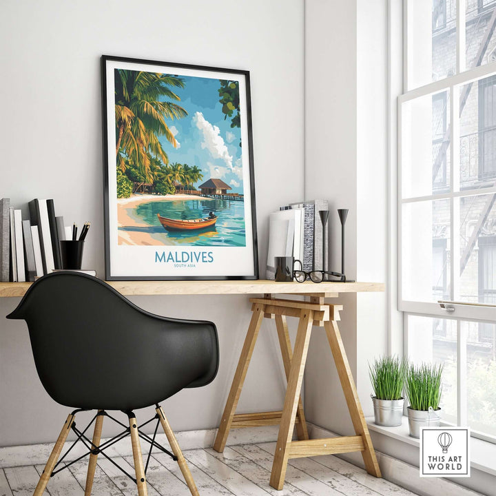 Maldives wall art print framed on a desk in a bright room, featuring a tropical beach scene with a boat.