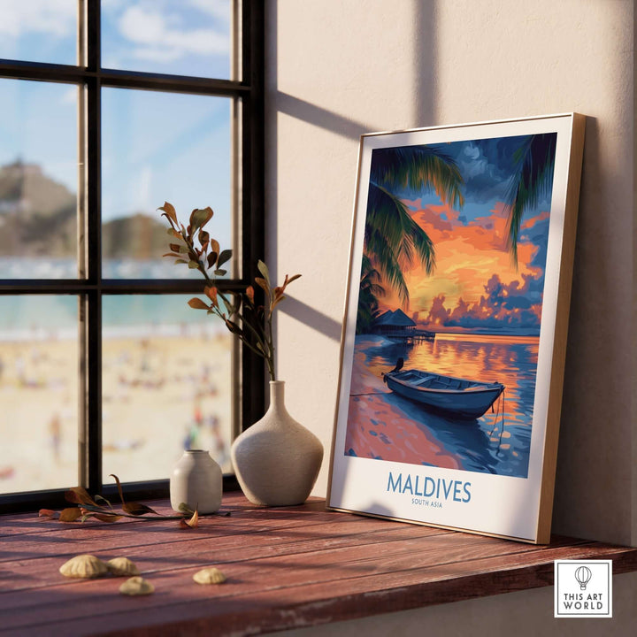 Maldives wall art print featuring a vibrant sunset and tranquil boat by a window with beach view.