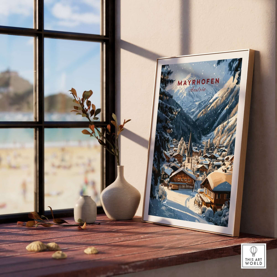 Mayrhofen Ski Wall Art Print displayed on a wooden table by a window, showcasing a snowy mountain village scene.