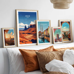 Moab Utah Wall Art collection featuring vibrant landscapes and cityscapes in stylish frames on a modern couch.