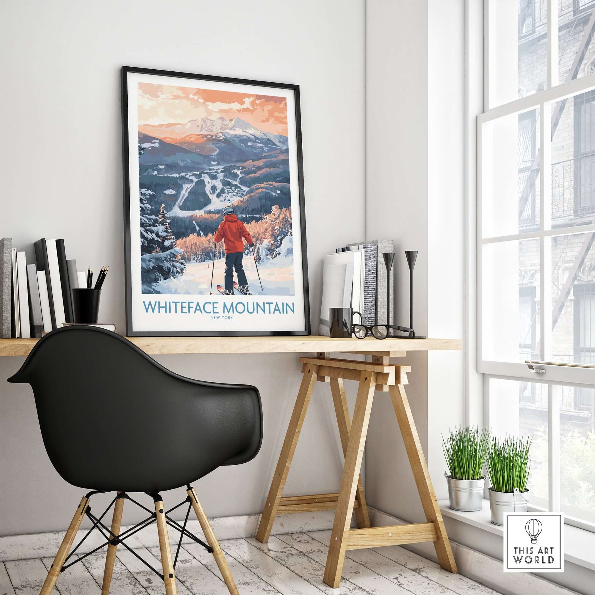 Framed Whiteface Mountain ski print in modern workspace, showcasing snowy slopes and a skier overlooking the scene.