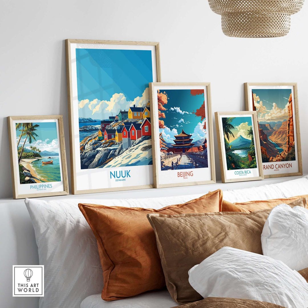 Colorful Nuuk travel poster among framed art showcasing global destinations on a cozy couch display.