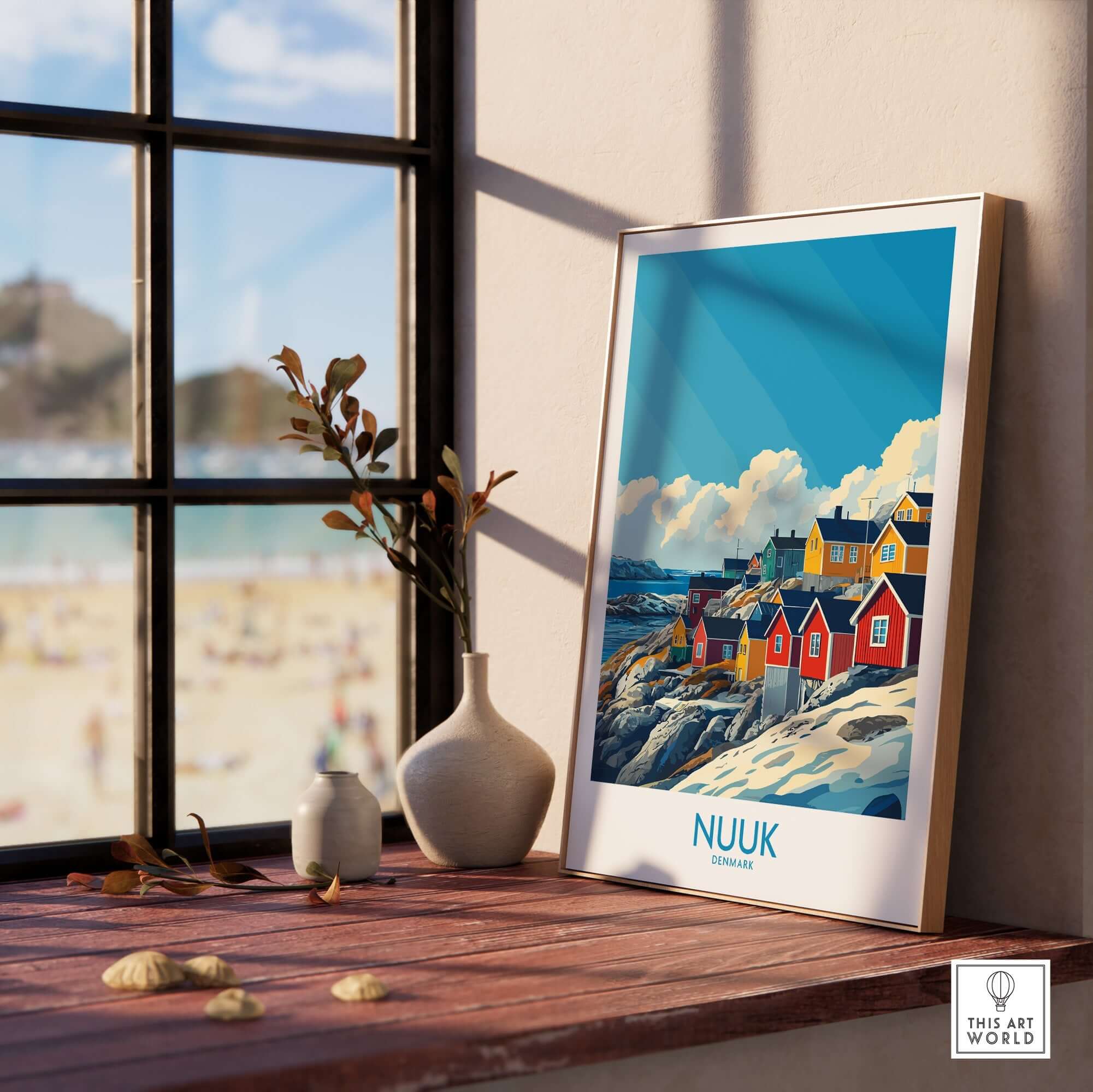 Nuuk Travel Poster displayed in a bright room with a beach view, showcasing colorful houses and capturing Greenland's beauty.