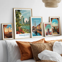 Framed travel posters of Paris, Panama City, Copenhagen, Tokyo, and Barcelona displayed above a bed with cozy pillows.