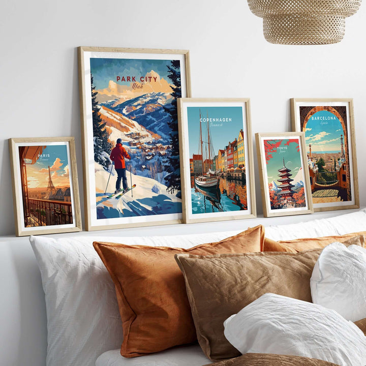 Park City Ski Wall Art prints displayed on a cozy bedroom wall with decorative pillows, showcasing skiing and cityscapes.