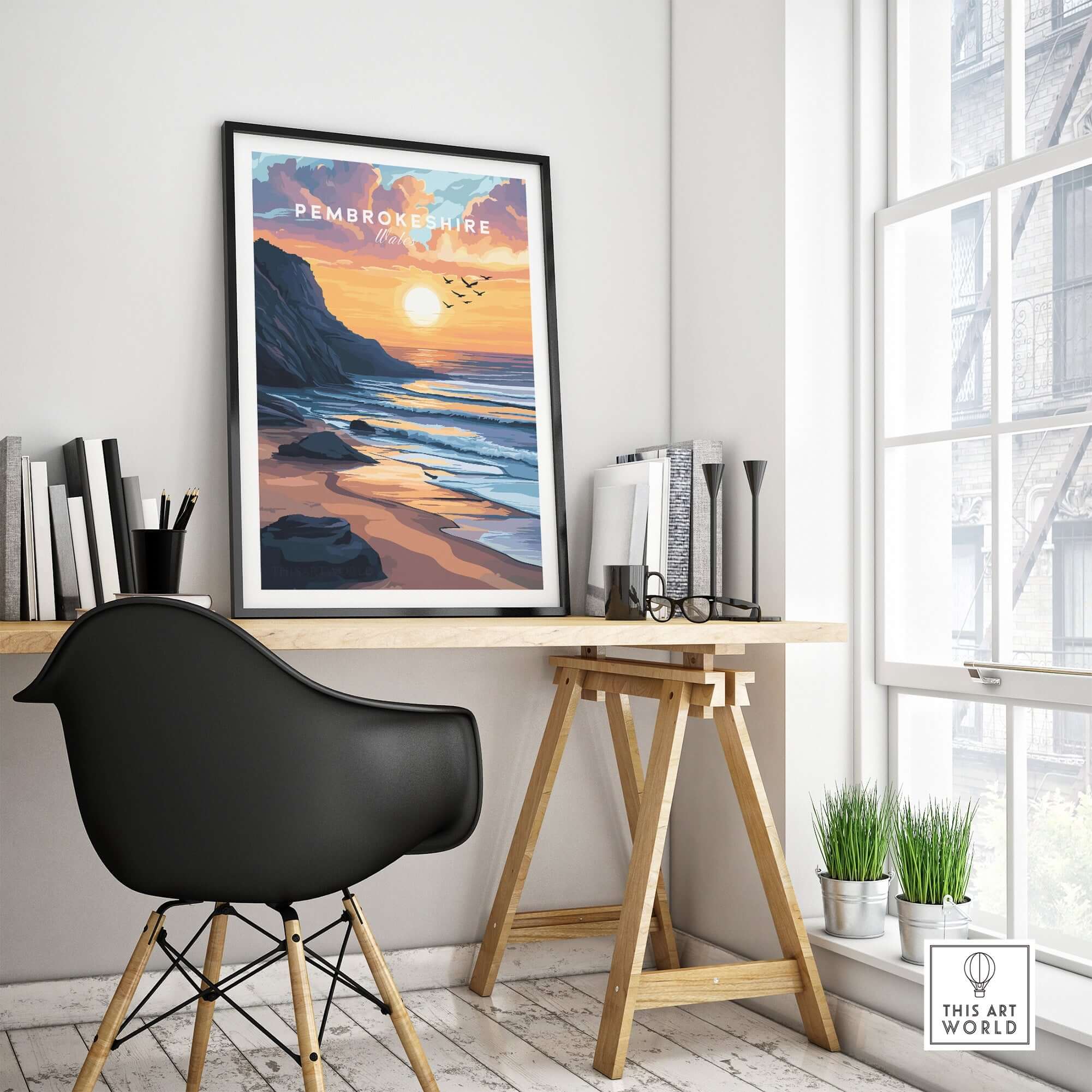 Pembrokeshire Coast Wales Travel Print displayed on a wall above a desk in a modern home office setting.