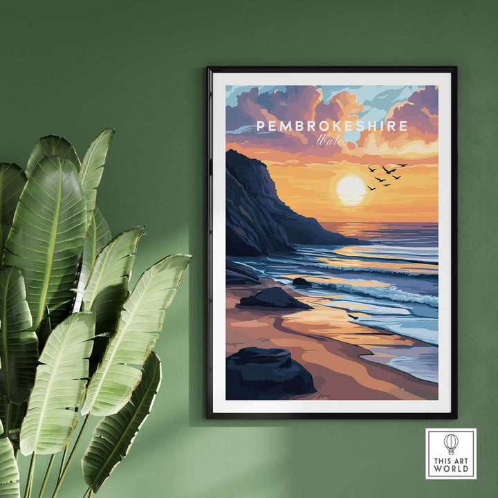 Pembrokeshire Coast Wales travel print featuring a vibrant sunset over the shore and cliffs, framed on a green wall.