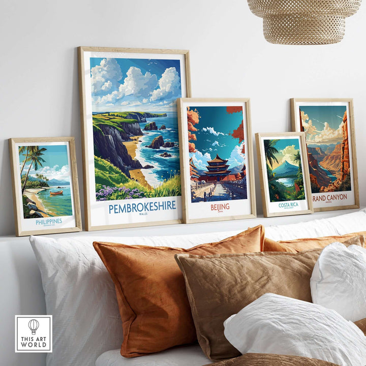 Vibrant Pembrokeshire poster among framed travel prints, showcasing stunning landscapes and coastal beauty in a stylish interior setting.