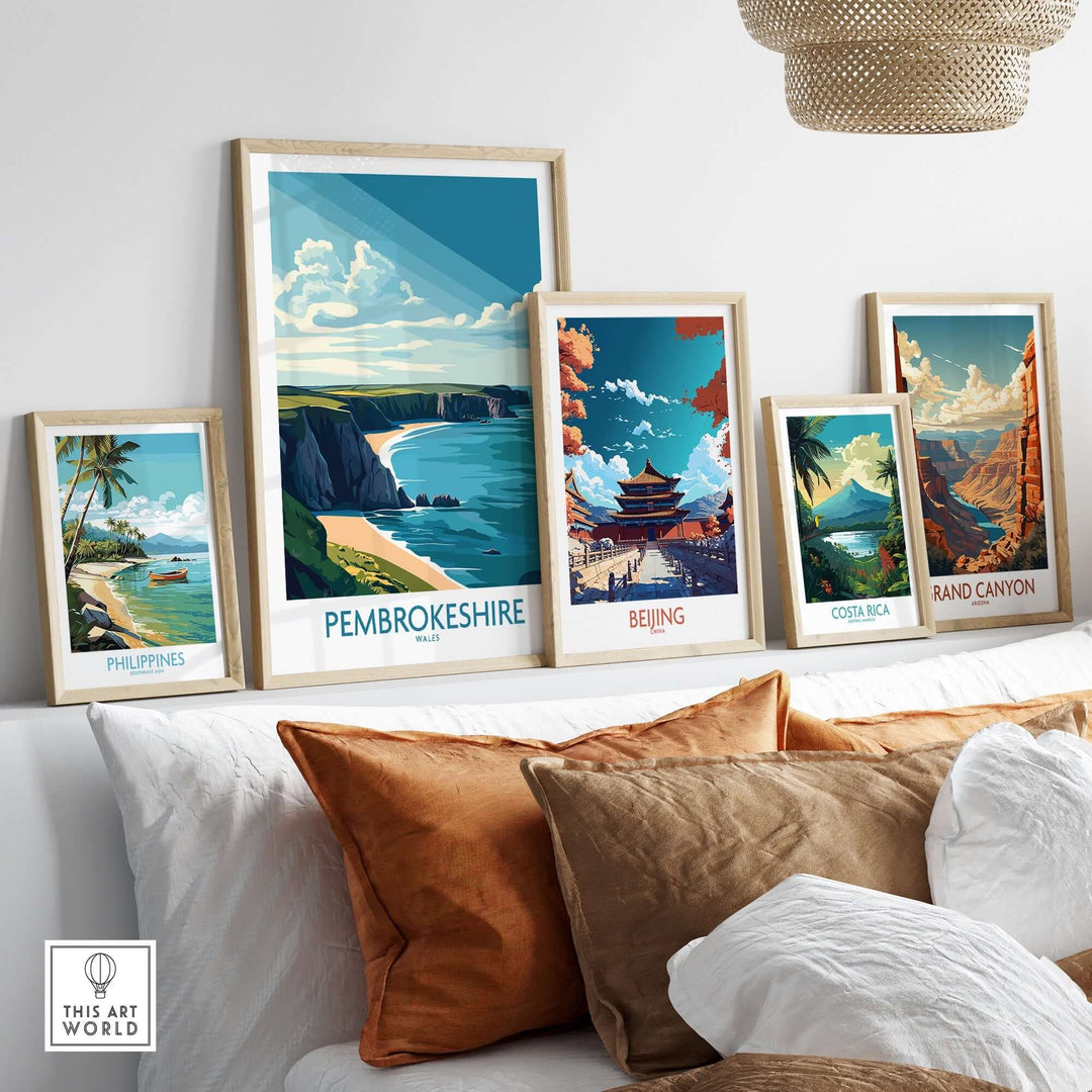 Vibrant Pembrokeshire poster among framed travel art showcasing scenic views of various destinations on a modern wall.