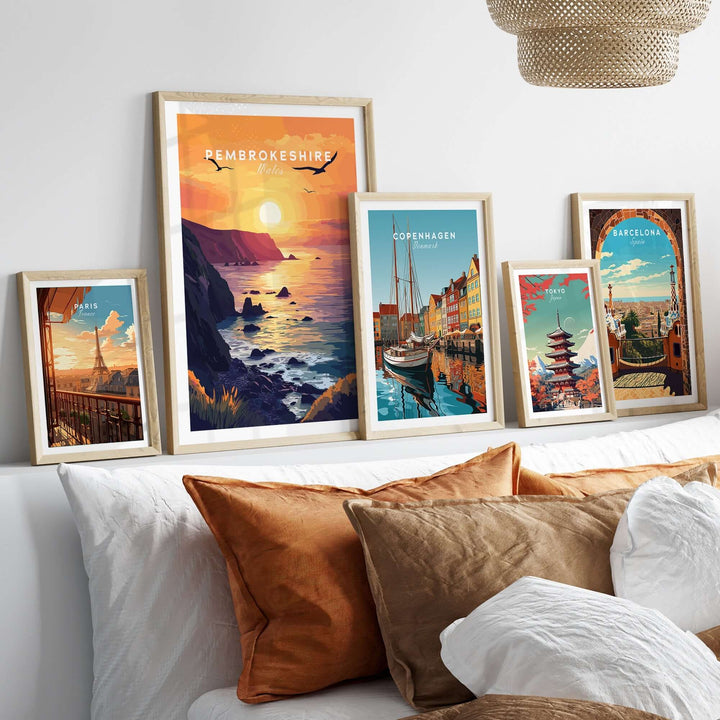 Beautifully framed Pembrokeshire Wales wall art displayed on a bed with decorative pillows, showcasing vibrant sunset colors.