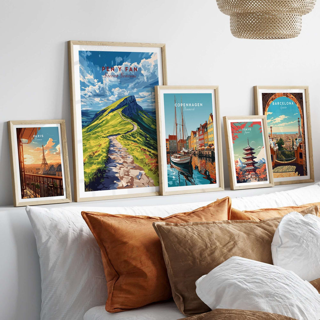 Pen Y Fan print among framed travel art on a stylish wall above a cozy bed with decorative pillows.