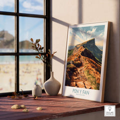 Pen Y Fan Wall Art Brecon Beacons Wales displayed on a wooden shelf with a scenic view through the window.