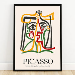 Abstract Picasso-style portrait print with colorful lines in a black frame on a wooden floor.