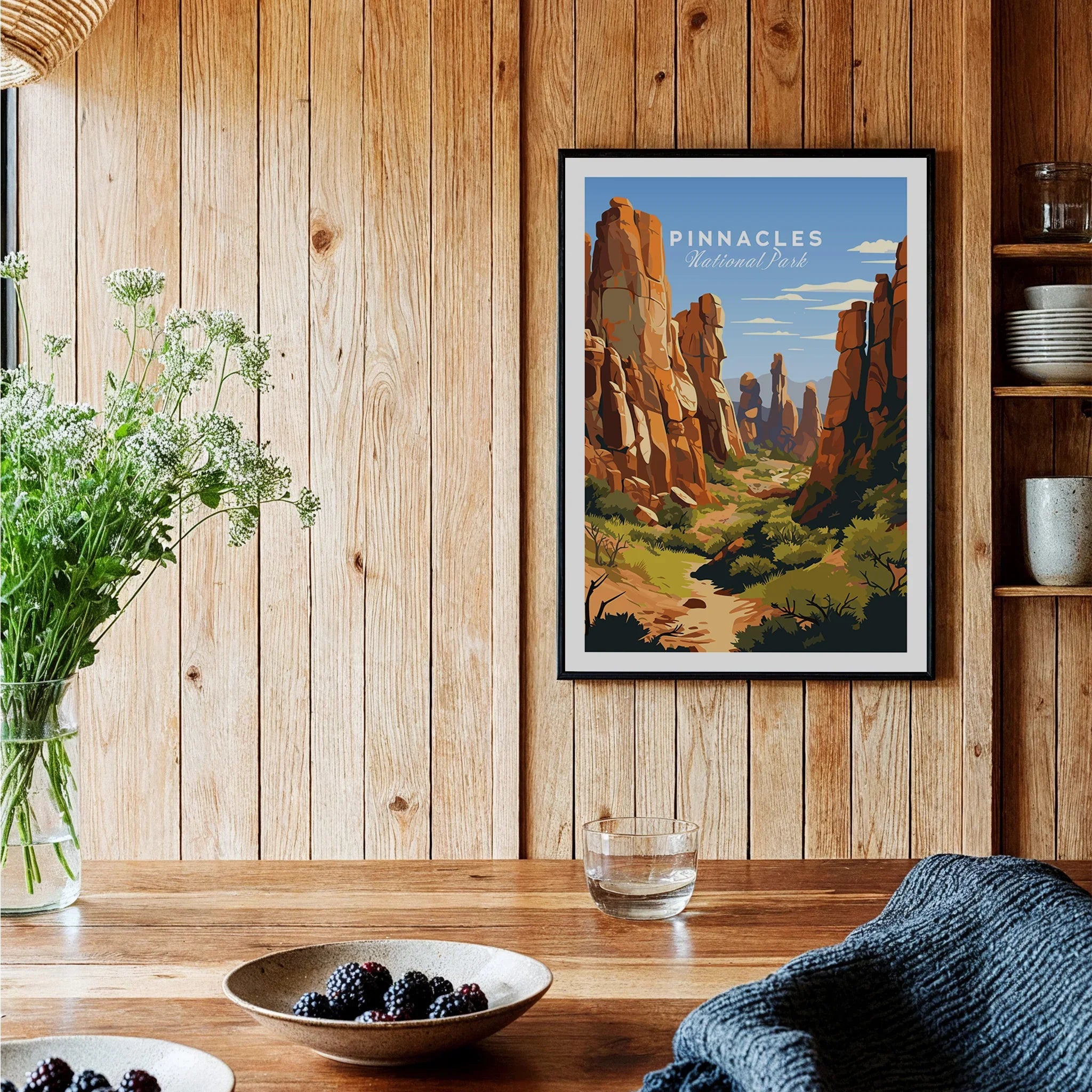 Framed Pinnacles National Park art print on wood wall in rustic kitchen with flowers and berries