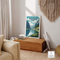 Norway fjords travel poster displayed in a stylish living room, showcasing stunning mountains and serene reflections.