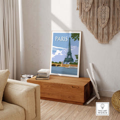 Eiffel Tower travel poster displayed in a modern living room setting with wooden decor and cozy furnishings.