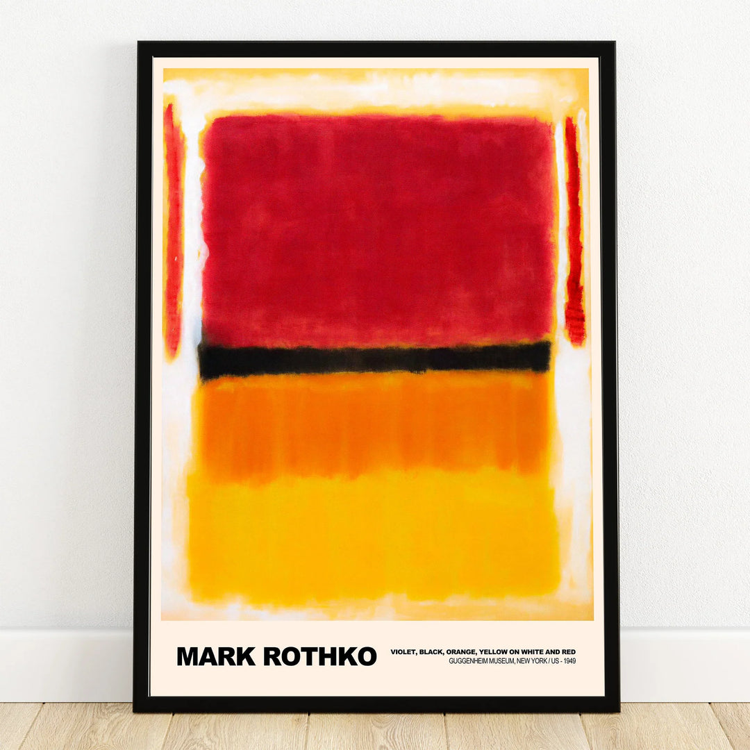 Framed abstract art print with bold red, black, and yellow color blocks resting on floor.