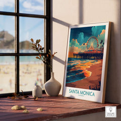 Santa Monica Pier Poster – California Wall Art displayed on a shelf by a window, with a beach view.