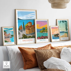 Collection of framed art prints featuring Macedonia, Lake Como, Amalfi Coast, San Juan, and Maui on a stylish couch.