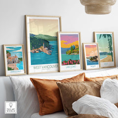 Collection of vintage landscape wall art prints including West Vancouver, Lake Como, and Amalfi Coast, displayed on a couch.
