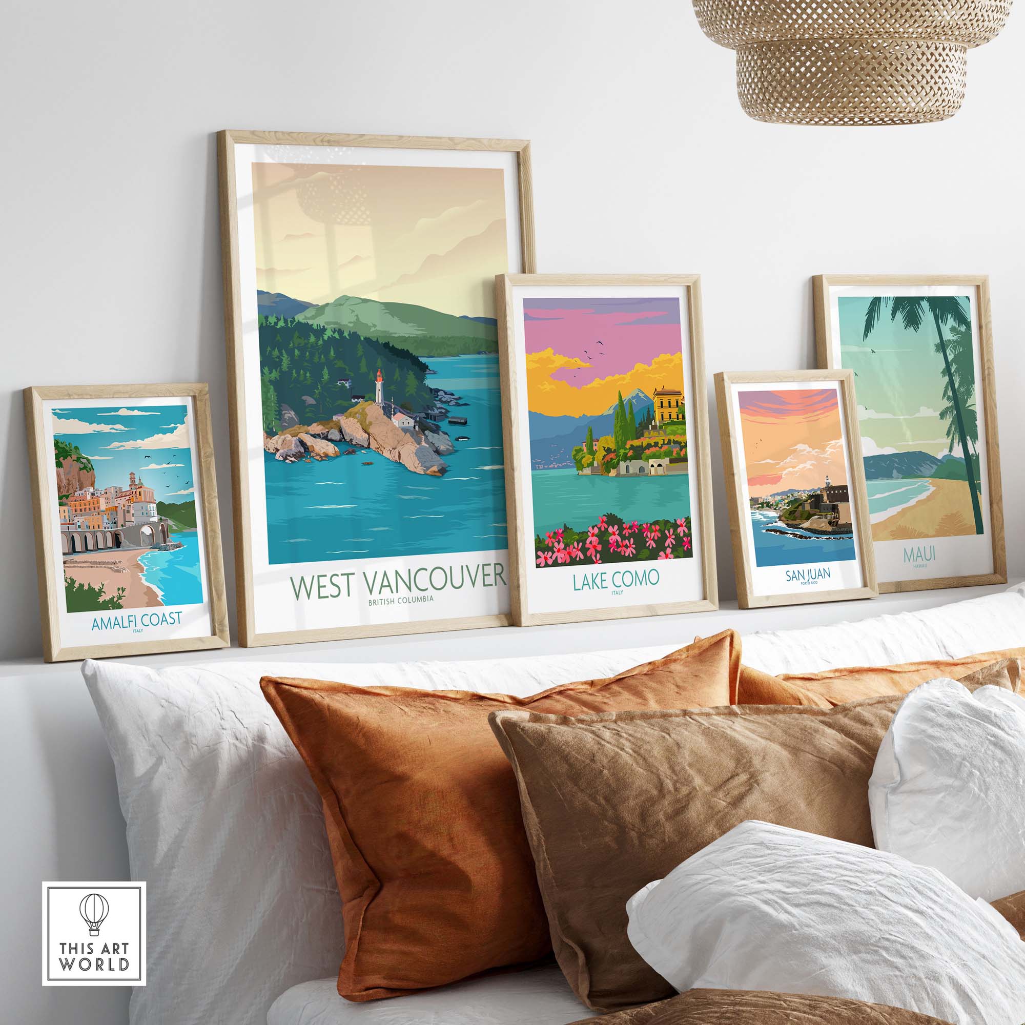Collection of vintage landscape wall art prints including West Vancouver, Lake Como, and Amalfi Coast, displayed on a couch.