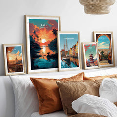 Bali wall art prints displayed on a cozy bed, featuring picturesque scenes from Bali, Copenhagen, and Barcelona.