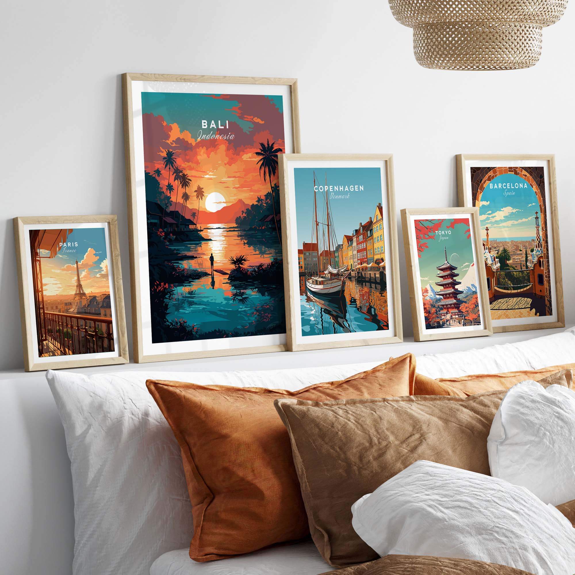 Bali wall art prints displayed on a cozy bed, featuring picturesque scenes from Bali, Copenhagen, and Barcelona.