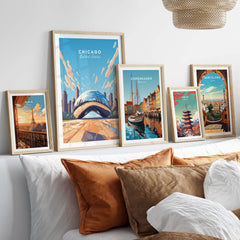 Collection of vibrant city posters in frames, featuring Chicago, Copenhagen, and Barcelona decor on a cozy bed.