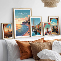 Colorful Côte d'Azur travel poster prints displayed on a cozy bed, enhancing wall art aesthetics.