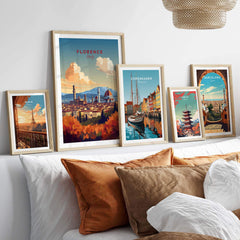 Framed Florence Italy art print among a collection of travel posters on a stylish bed setting.