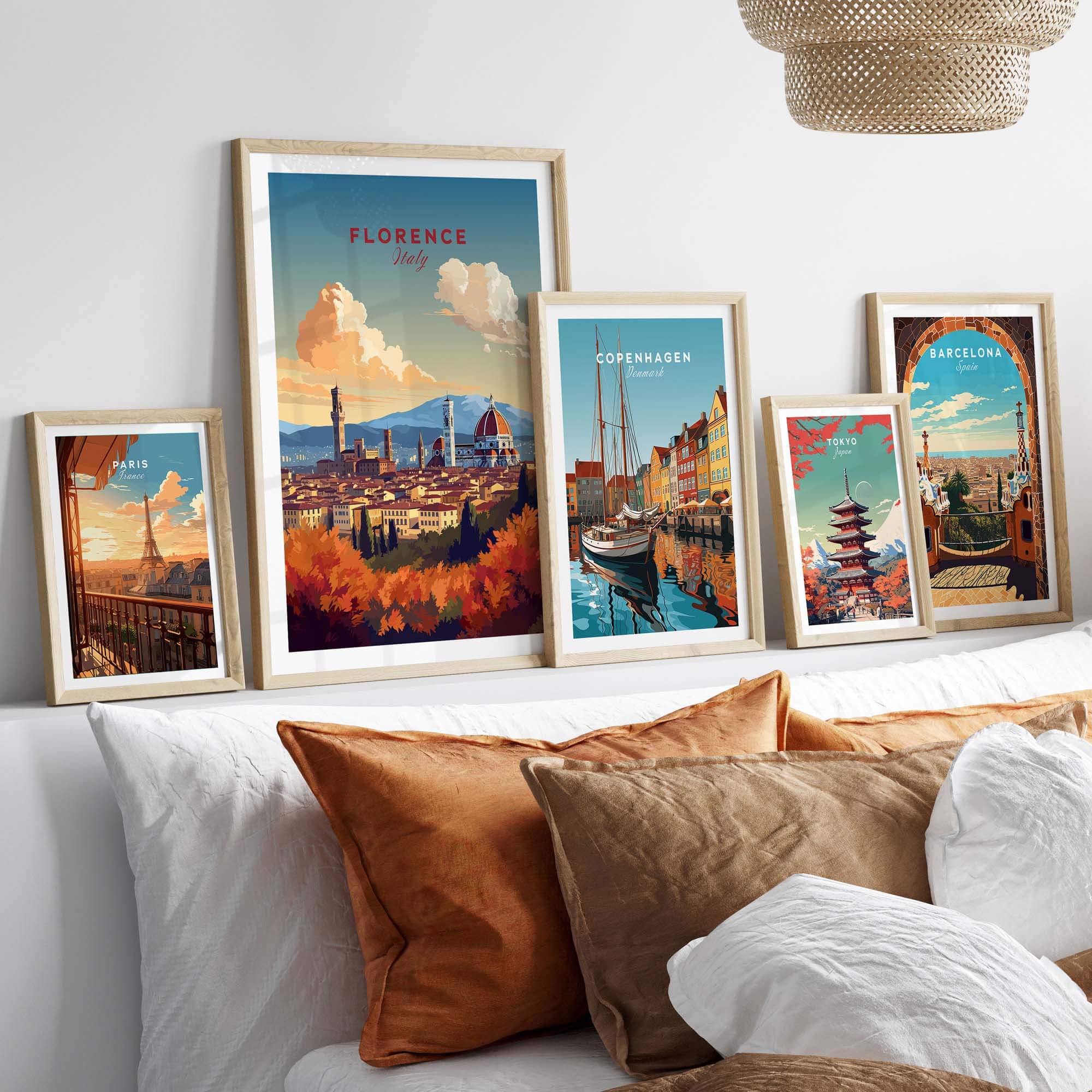 Framed Florence Italy art print among a collection of travel posters on a stylish bed setting.