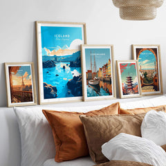 Gallery of travel posters including Blue Lagoon Iceland, displayed above a cozy bed with decorative pillows.