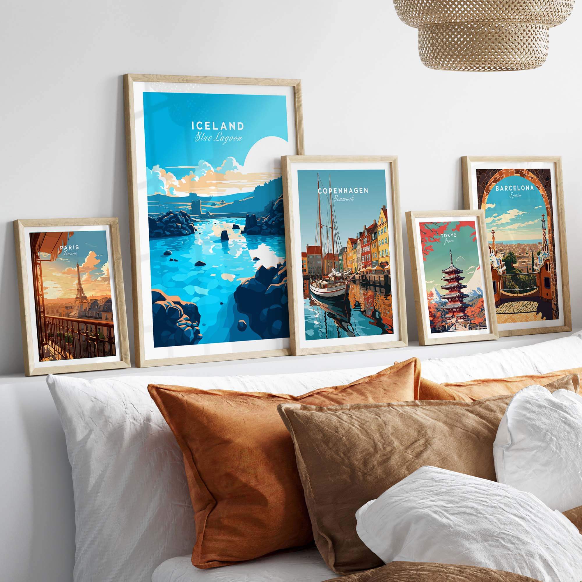 Gallery of travel posters including Blue Lagoon Iceland, displayed above a cozy bed with decorative pillows.