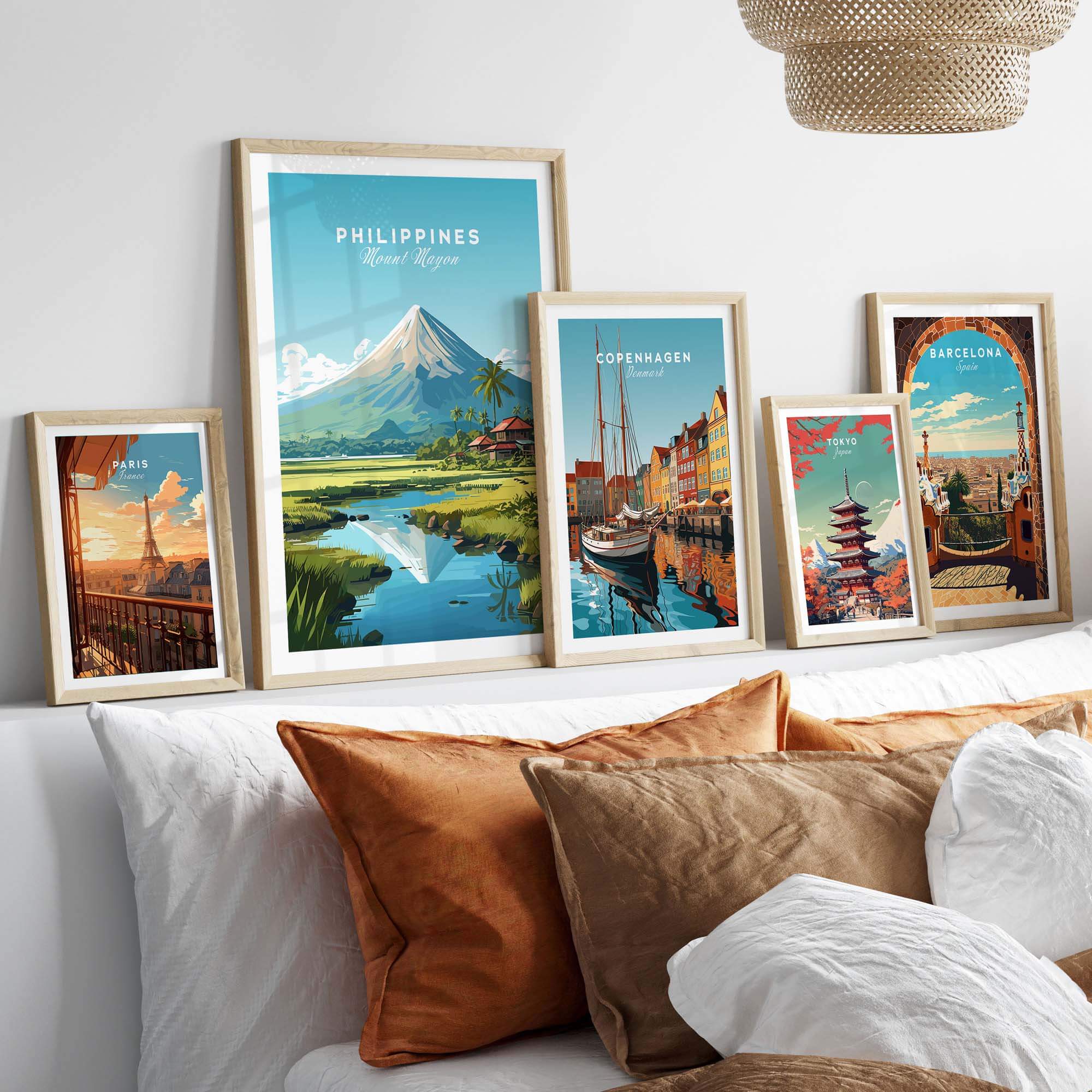 Philippines travel poster featuring Mount Mayon, displayed among various international art prints on a cozy sofa.
