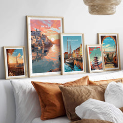 Framed travel poster prints of Skyros, Copenhagen, and Barcelona displayed in a cozy living room setting.