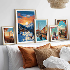 Framed Whistler Ski Resort poster with sunset, displayed alongside other travel posters, on a living room wall.