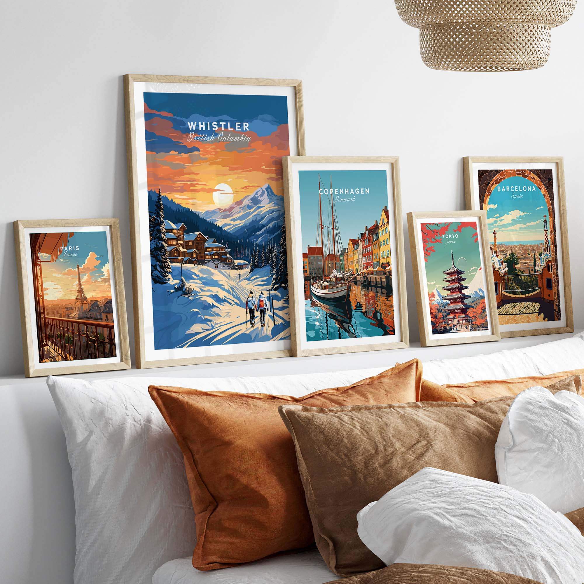 Framed Whistler Ski Resort poster with sunset, displayed alongside other travel posters, on a living room wall.