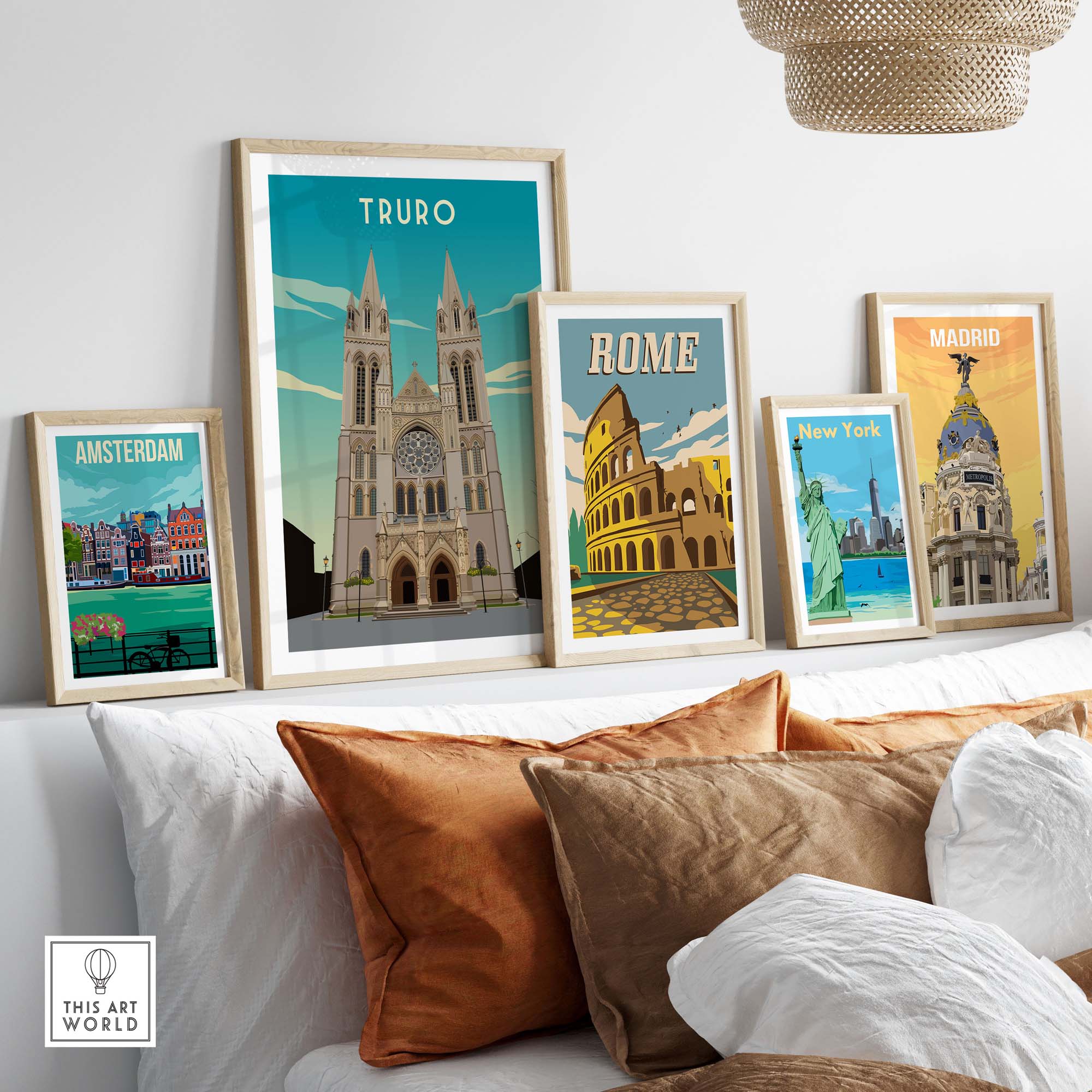 Framed travel poster prints featuring Truro, Rome, Amsterdam, New York, and Madrid on a stylish sofa.